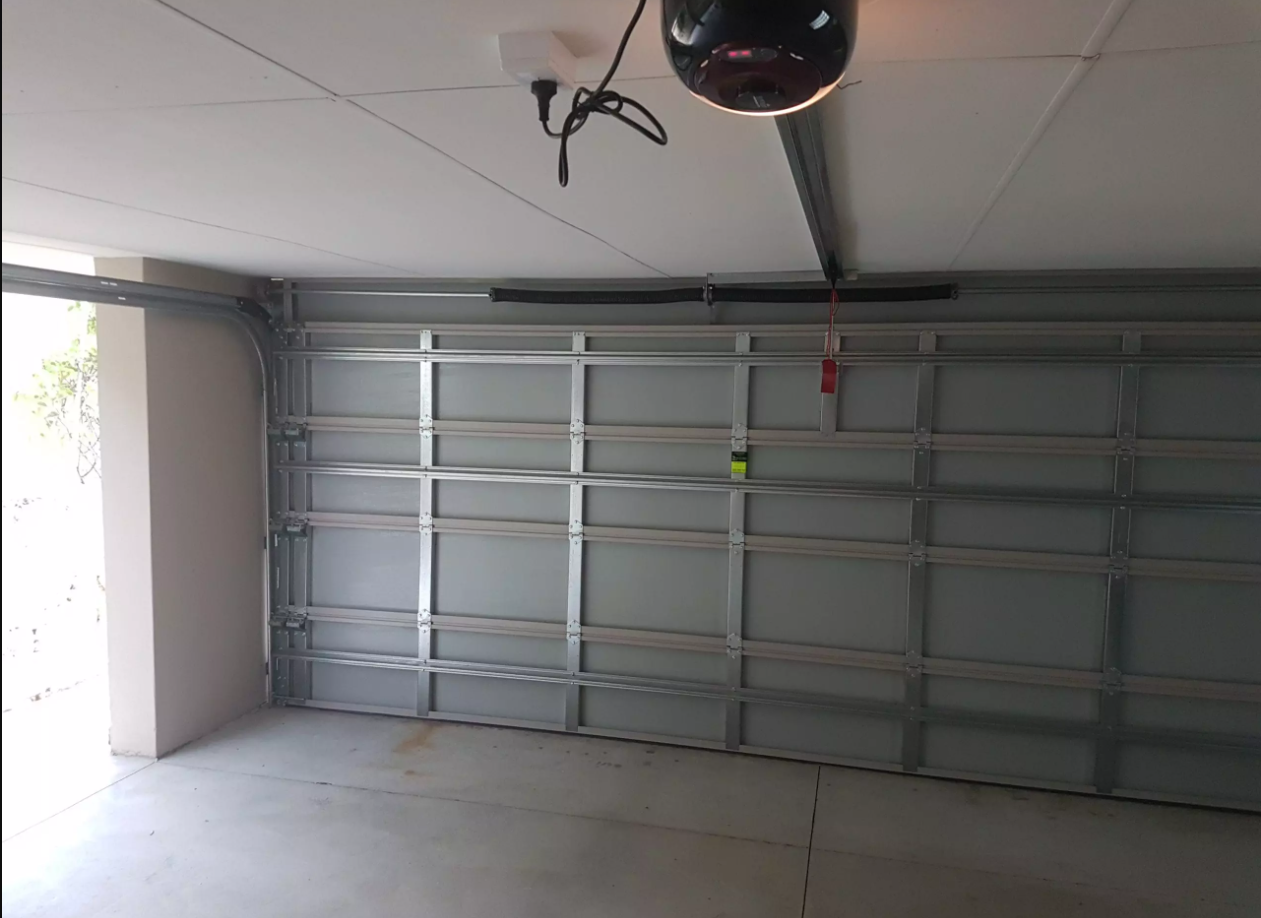 Technician performing a garage door section replacement in Venice, Florida, ensuring smooth and efficient operation for residential property owners.